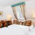 Guest room at Churfuerstliche Waldschaenke in Moritzburg with twin beds, desk, TV and window seating