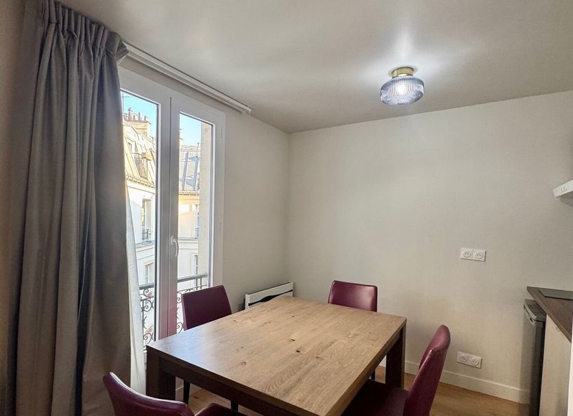 Villa Montmartre in Paris: small dining area with wooden table, four chairs, and window view