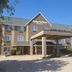 AmericInn by Wyndham Galesburg exterior with covered entrance and clear blue sky