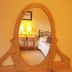 Ard na Breatha in Donegal bedroom reflected in an oval mirror with bedside lamps and a bed