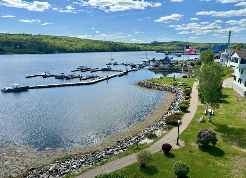 Fort Knox Inn in Bucksport with harbor view, docked boats, waterfront path, and grassy shoreline