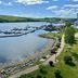 Fort Knox Inn in Bucksport with harbor view, docked boats, waterfront path, and grassy shoreline