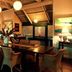 Pinctada Mcalpine House Broome dining room with long table, wicker chairs and tropical artwork