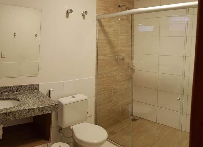 Bravo City Hotel in Campo Grande bathroom with sink, toilet, and walk-in glass shower