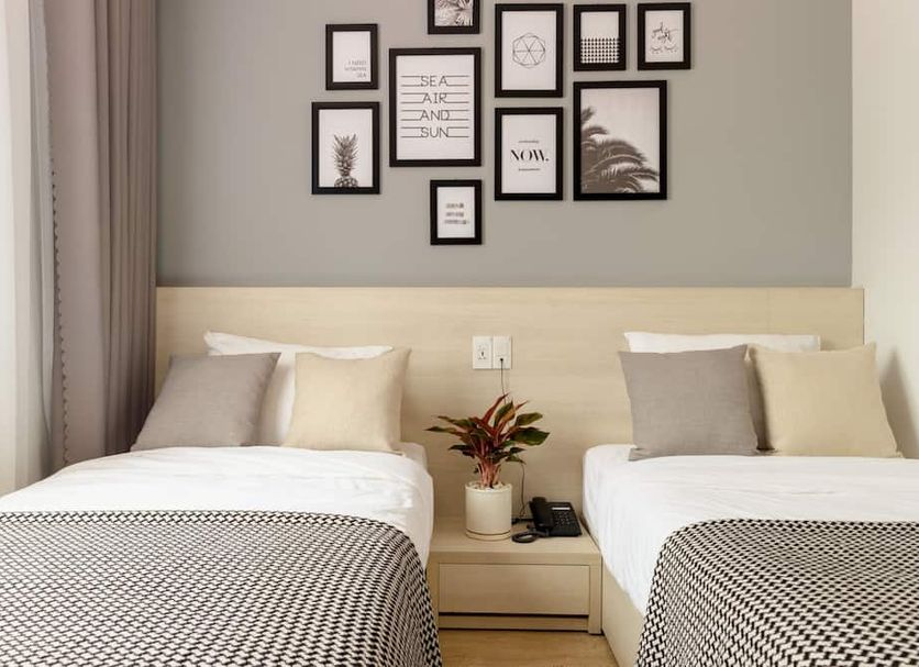 The Pergola Design Hotel in Da Nang guest room with two twin beds and framed wall art
