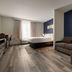 La Quinta Inn & Suites by Wyndham Montgomery guest room with bed, sofa and desk