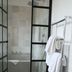Finca Hotel Rural Es Turó in Ses Salines bathroom with glass shower doors, bathtub, and towel rack