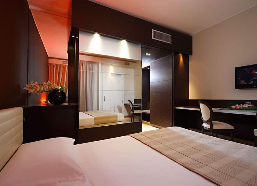 Just Hotel Lomazzo Fiera room with bed, desk, wall TV and glass-partitioned bathroom in Lomazzo