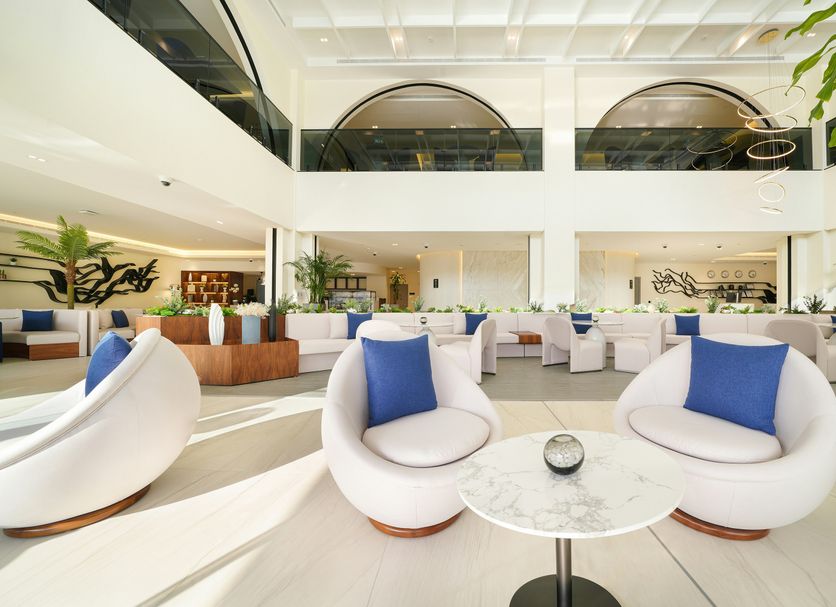 Nova M Olaya Hotel Edge By Rotana in Riyadh lobby with white lounge chairs, marble tables and airy atrium