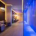 First Mountain Montafon in Gaschurn: blue-lit spa corridor with lounge seating and tiled pathway
