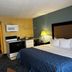 Regency Inn & Suites New London Mystic guest room with bed, kitchenette, and lamp in New London