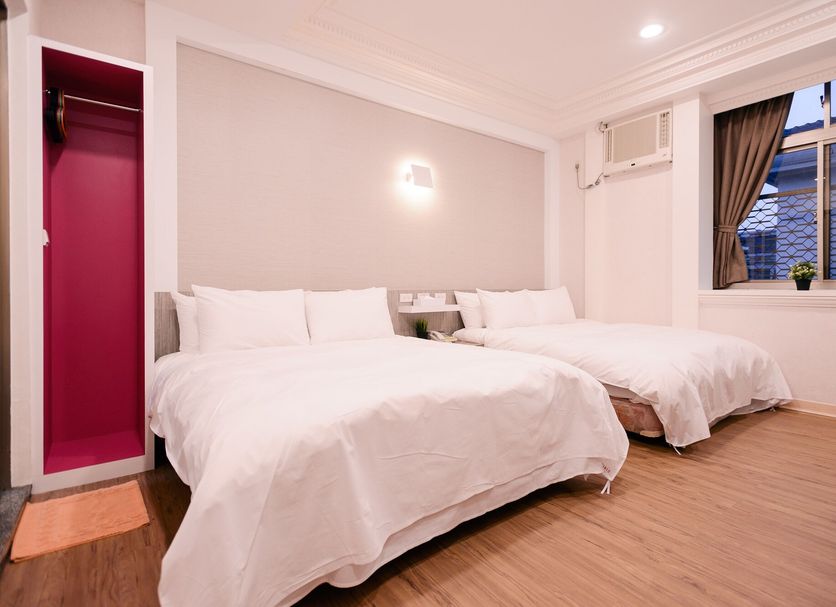 Guest Motel-Zhubei in Zhubei City guest room with two white beds, wood floor, and window