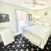 Quaker Inn in Ocean Grove guest room with white bed, dresser, ceiling fan, and floral carpet
