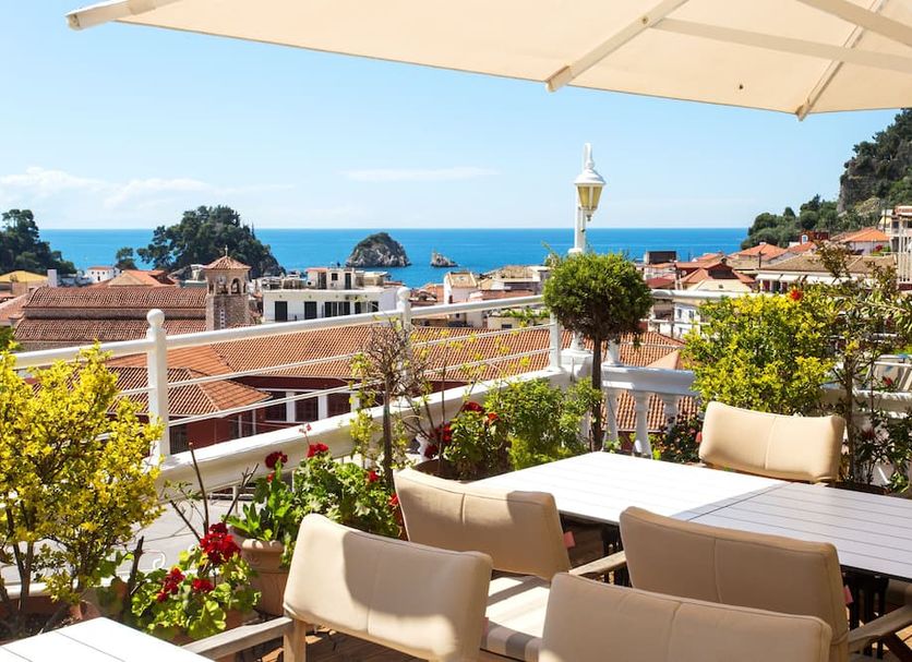 Olympic Hotel in Parga terrace with tables, umbrellas and sea and town views