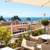 Olympic Hotel in Parga terrace with tables, umbrellas and sea and town views