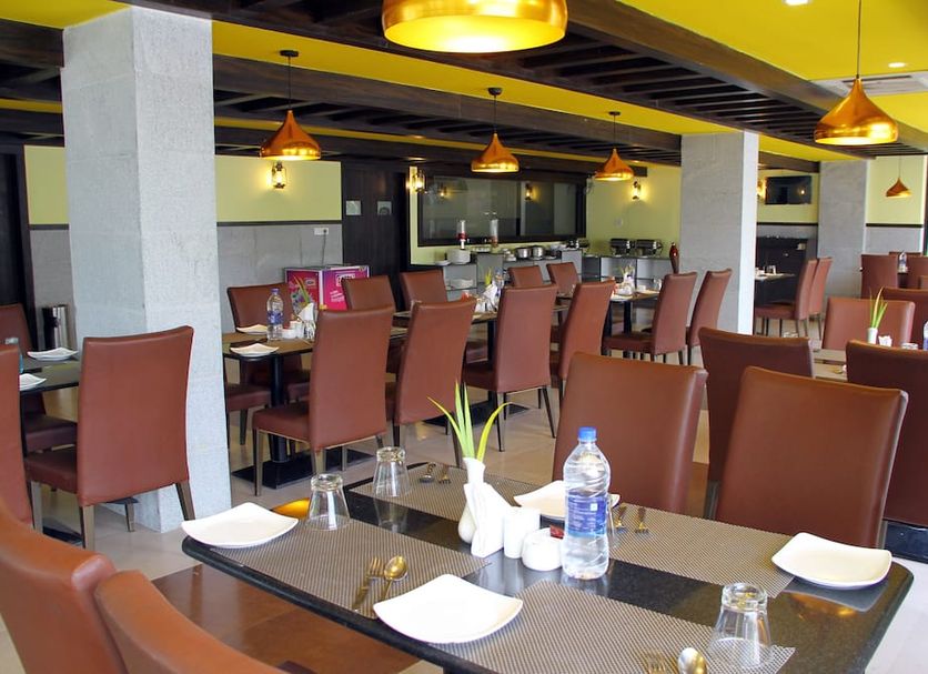 Vinayaga by Poppys, Kumbakonam restaurant dining area with tables and chairs