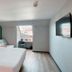 Campanile Vannes room with double bed, chair by window, and wall-mounted TV in Vannes