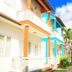 Volga Apartment Hotel in Mũi Né with colorful balconies and a palm-lined courtyard walkway