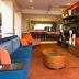 Courtyard by Marriott Kansas City East/Blue Springs lobby lounge with blue sofa, bar seating and TV