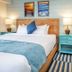 Surf House in Hampton guest room with king bed, mini fridge, microwave, and striped rug
