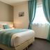 Relax Hôtel Beuzeville Honfleur guest room with king bed and teal accents in Honfleur
