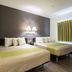 Studio 6 Bay City, TX guest room with two beds and a window with green curtains