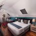 88 Baron van Reede Guesthouse in Oudtshoorn: attic room with king bed, twin bed, wood floors and skylight