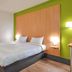 B&B HOTEL Herblay room with twin beds and green accent wall in Herblay