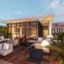 abba Sevilla rooftop terrace with lounge seating, glass-walled dining area and city skyline at dusk