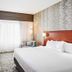 Courtyard by Marriott Knoxville Airport Alcoa guest room with king bed, desk, chair, and large window in Alcoa