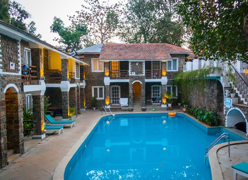 The Tamarind Hotel - A Boutique Heritage Stay, Anjuna - Goa courtyard pool with stone buildings and loungers