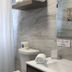 The Beach Guesthouse in La Torre bathroom with sink, toilet, towel, and decorative wall panel