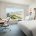 Luma Hotel San Francisco room with large window view of San Francisco and a modern bed