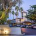 DoubleTree by Hilton Hotel Campbell - Pruneyard Plaza entrance with lit sign, palm trees, and parked cars