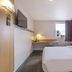 B&B HOTEL La Rochelle Centre guest room with bed, desk, wall-mounted TV and window