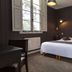 Hôtel & Spa du Domaine des Thômeaux, Mosnes room with double bed, window, desk and dark wood paneling