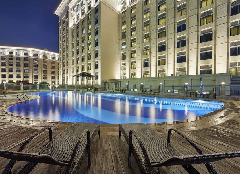 Haili Garden Hotel, Guangzhou: outdoor rooftop pool and lounge chairs beside the hotel at night