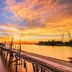 The Nagoya Plasa Redpartner in Batam overlooking a sunset-lit waterfront and wooden pier