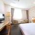 Koko Hotel Tomakomai guest room with bed, chairs, desk and large window in Tomakomai