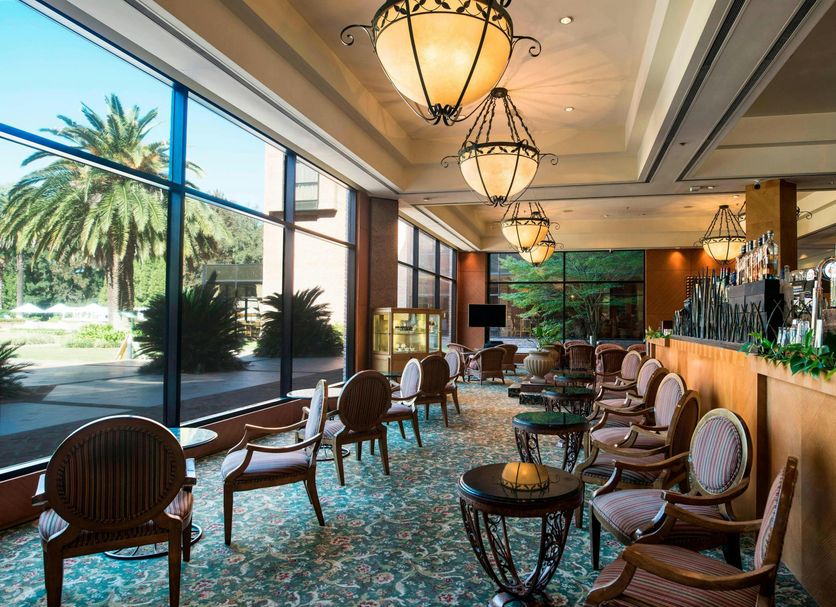 Sheraton Pilar Hotel & Convention Center lobby with lounge seating, bar, and large garden-view windows in Pilar