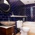 The Coal Exchange Hotel Cardiff bathroom with black tile walls, stone sink, toilet and bathtub