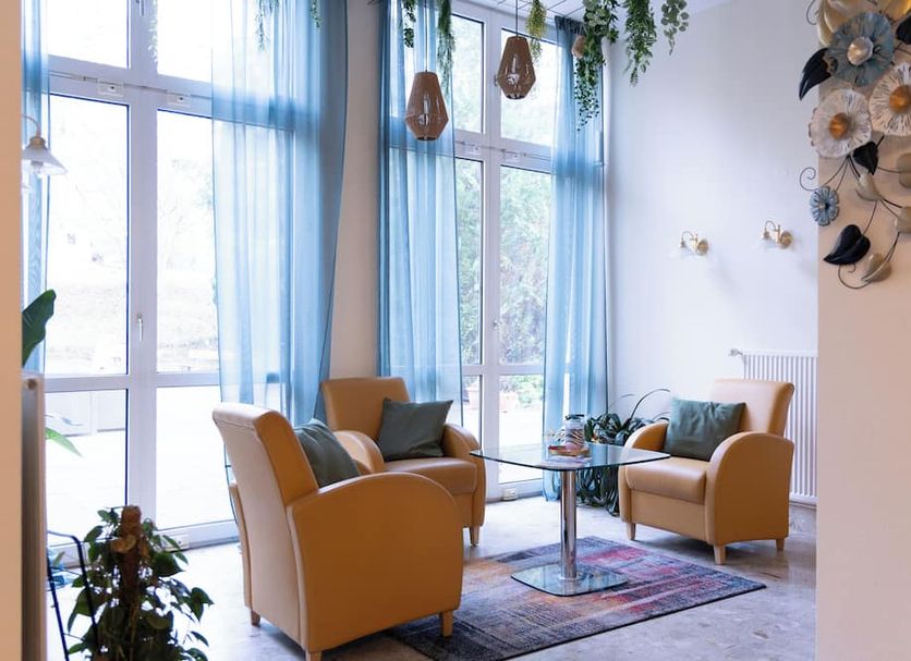 Hotel Haus am Park in Bad Homburg lobby seating area with armchairs, glass table and tall windows