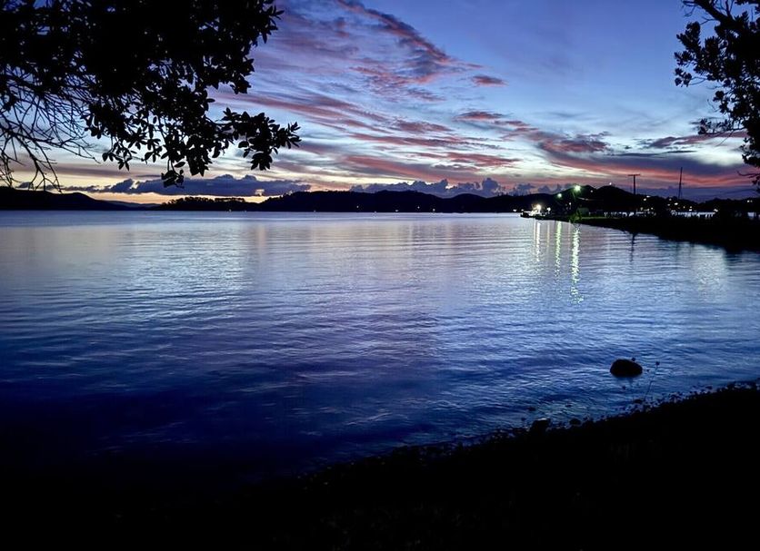 Anchor Lodge Motel in Coromandel with tranquil waterfront view at dusk and colorful sunset sky