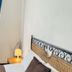 Novella Italy Florence hotel room with wrought-iron bed, bedside lamp, and blue curtains by window