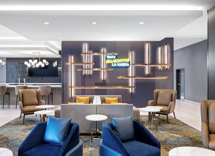 La Quinta Inn & Suites by Wyndham La Habra lobby with seating area and neon sign in La Habra