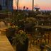 Sunset view from Tilghman Island Inn terrace in Tilghman Island with outdoor tables, planters, and water beyond