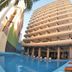 Hotel Playa Bonita in Mazatlán with a poolside view of the tall beachfront tower and lounge chairs