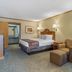 SureStay by Best Western Kansas City Country Inn North guest room with king bed, desk, and seating