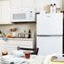 Intown Suites Extended Stay Huntsville AL - NASA kitchen with white cabinets, fridge, microwave and dining table