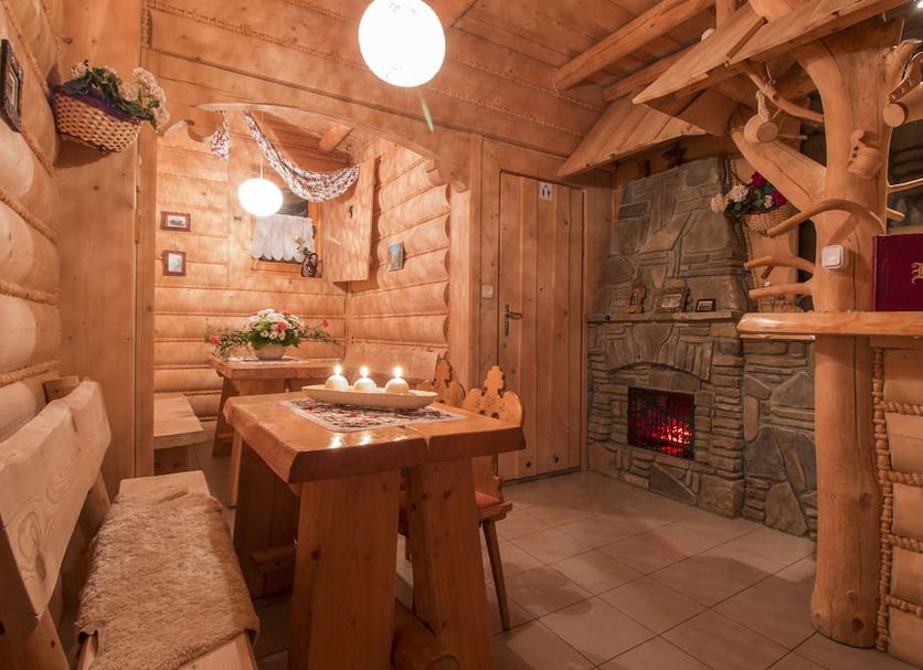 Dom Wypoczynkowy U Staszla in Bańska cozy rustic wooden room with stone fireplace and table